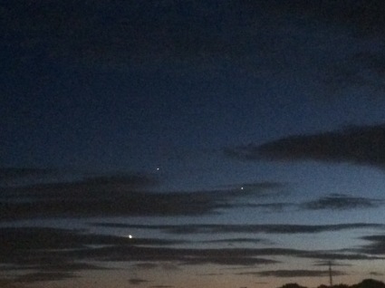 Night sky, the moon poking through the clouds, Venus and Jupiter visible above and to the right, 